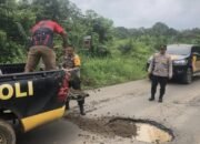 Kapolsek BTS Ulu Polres Musi Rawas Respon Cepat Timbun Jalan Berlubang Cegah Kecelakaan,,,